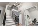 Bright foyer with modern chandelier, and staircase with iron railings leading to the upper level at 10 Summit Ash, Littleton, CO 80127