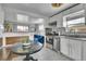 Stylish dining area with stainless steel appliances, an adjacent kitchen, and a view of the living room at 7001 Alan Dr, Denver, CO 80221
