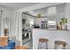 Bright kitchen with stainless steel appliances, subway tile backsplash, and an open view of the living room at 7001 Alan Dr, Denver, CO 80221