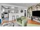 Open-concept living room with kitchen view, modern decor, hardwood floors, and cozy seating at 7001 Alan Dr, Denver, CO 80221