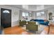 Inviting living room with hardwood floors, comfortable seating, natural light, and a black front door at 7001 Alan Dr, Denver, CO 80221