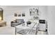Inviting living space with a gray sofa, glass dining table, and convenient kitchenette with mini fridge at 7001 Alan Dr, Denver, CO 80221