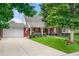 Charming brick home featuring a well-manicured lawn, mature trees, and an inviting covered front porch at 3450 E Easter Ave, Centennial, CO 80122