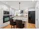 Modern kitchen featuring white cabinets, a large island, hardwood floors, and stainless steel appliances at 3450 E Easter Ave, Centennial, CO 80122