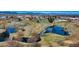 Scenic aerial view of neighborhood ponds with a golf course and mountains in the distance at 325 Mulberry Cir, Broomfield, CO 80020