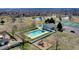 Aerial view of a blue house featuring a pool, playground, and tennis court on a sunny day at 325 Mulberry Cir, Broomfield, CO 80020