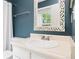 This bathroom features a decorative mirror, a neutral countertop, and blue accent walls at 325 Mulberry Cir, Broomfield, CO 80020