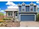 Charming two-story home features a blue exterior, attached garage, and manicured landscaping at 325 Mulberry Cir, Broomfield, CO 80020