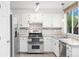 Kitchen features stainless steel appliances, white cabinetry and tile backsplash at 325 Mulberry Cir, Broomfield, CO 80020