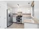 Kitchen features stainless steel appliances, white cabinetry and tile backsplash at 325 Mulberry Cir, Broomfield, CO 80020