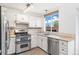 Kitchen features stainless steel appliances, white cabinetry and tile backsplash at 325 Mulberry Cir, Broomfield, CO 80020