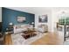 Staged living room with blue accent wall, neutral furniture, and hardwood flooring at 325 Mulberry Cir, Broomfield, CO 80020