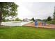View of the playground with a fence and a tennis court, and a house in the background at 325 Mulberry Cir, Broomfield, CO 80020