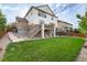 Expansive backyard featuring lush lawn, stone accents, deck, and play area with swings and trampoline at 6236 S Millbrook Way, Aurora, CO 80016