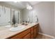 Bathroom featuring double sinks, light wood cabinets, and a large mirror creating a functional design at 6236 S Millbrook Way, Aurora, CO 80016