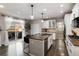 Bright kitchen with a center island, bar stools, stainless appliances, and access to the patio at 6236 S Millbrook Way, Aurora, CO 80016
