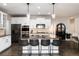 Open kitchen with a large island, bar seating, stainless steel appliances, and white cabinetry at 6236 S Millbrook Way, Aurora, CO 80016