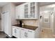 Butler's pantry area with white cabinets, granite countertops, and storage for glassware at 6236 S Millbrook Way, Aurora, CO 80016