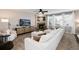Spacious living room with a fireplace, plush white sofa, media cabinet, and abundant natural light at 6236 S Millbrook Way, Aurora, CO 80016