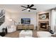 Spacious living room with a fireplace, plush white sofa, media cabinet, and abundant natural light at 6236 S Millbrook Way, Aurora, CO 80016