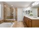 Elegant main bathroom featuring a soaking tub, glass-enclosed shower, and double sink vanity at 6236 S Millbrook Way, Aurora, CO 80016