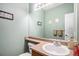 Powder room featuring a sleek vanity, a large mirror, and modern fixtures, perfect for guests and convenience at 11499 Kenton St, Commerce City, CO 80640