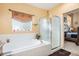 Bathroom featuring a garden tub, a glass enclosed shower, and access to the bedroom in a cozy aesthetic at 11499 Kenton St, Commerce City, CO 80640