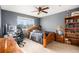 Bedroom featuring a decorative ceiling fan, wood furniture, and a large window at 11499 Kenton St, Commerce City, CO 80640