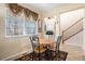 Cozy dining area with a round table, stylish chairs, and a large window with decorative curtains at 11499 Kenton St, Commerce City, CO 80640