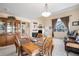 Inviting dining area with a wood table, ornate chairs, and views of the neighborhood through large windows at 11499 Kenton St, Commerce City, CO 80640