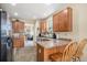 Cozy kitchen with wood cabinets, breakfast bar, and view into the living room, perfect for entertaining and Gathering time at 11499 Kenton St, Commerce City, CO 80640