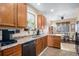 Traditional kitchen showcasing wood cabinetry, double sink, and view into breakfast nook at 11499 Kenton St, Commerce City, CO 80640