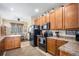 Well-lit kitchen features wood cabinetry, modern black appliances, and an adjacent dining area with large windows at 11499 Kenton St, Commerce City, CO 80640