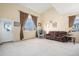 Bright living room featuring vaulted ceilings, large windows, and a comfortable seating area with a leather sofa at 11499 Kenton St, Commerce City, CO 80640