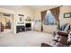 Cozy living room with a fireplace, built-in shelves, and large windows, creating a warm and inviting atmosphere at 11499 Kenton St, Commerce City, CO 80640