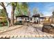 Landscaped backyard with gravel, stone pavers, and outdoor dining and grilling spaces under pergolas at 6045 S Cook St, Centennial, CO 80121