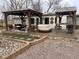 Inviting backyard featuring a covered patio, outdoor furniture, a built in grill, and landscape stone at 6045 S Cook St, Centennial, CO 80121