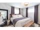 Cozy bedroom with patterned wallpaper, layered curtains, and a comfortable queen sized bed at 6045 S Cook St, Centennial, CO 80121
