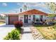 Attractive home with a stone pathway, gray brick facade, and a lush, landscaped front yard at 6045 S Cook St, Centennial, CO 80121