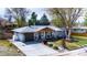 Well-maintained single-story home featuring a gray brick exterior, tidy landscaping, and a wooden garage door at 6045 S Cook St, Centennial, CO 80121