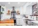 Bright kitchen with stainless steel appliances, white cabinets, and a farmhouse sink at 6045 S Cook St, Centennial, CO 80121