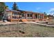 Charming single-story home featuring a large front porch, stone pillars, and solar panels at 1340 Deerpath Trl, Franktown, CO 80116