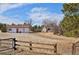 Property with fencing, a detached garage, and additional building set on open land with mature trees at 1340 Deerpath Trl, Franktown, CO 80116