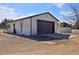 This garage has a brown door, extra tall ceilings, and an outbuilding at 1340 Deerpath Trl, Franktown, CO 80116