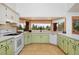 Charming kitchen featuring green cabinets and a large bay window with scenic views at 1340 Deerpath Trl, Franktown, CO 80116