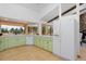Well-lit kitchen with green cabinetry, tile flooring, and views of the outdoors at 1340 Deerpath Trl, Franktown, CO 80116