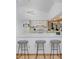 Open-concept kitchen featuring updated appliances, white cabinetry, and a breakfast bar with seating at 1340 Deerpath Trl, Franktown, CO 80116