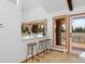 Bright kitchen area with breakfast bar and beautiful outdoor views through large bay windows at 1340 Deerpath Trl, Franktown, CO 80116