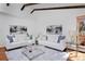 Elegant living room featuring hardwood floors, beamed ceilings, contemporary decor, and ample seating at 1340 Deerpath Trl, Franktown, CO 80116