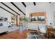 Bright living room boasting high ceilings, exposed beams, hardwood floors, and views of the property at 1340 Deerpath Trl, Franktown, CO 80116